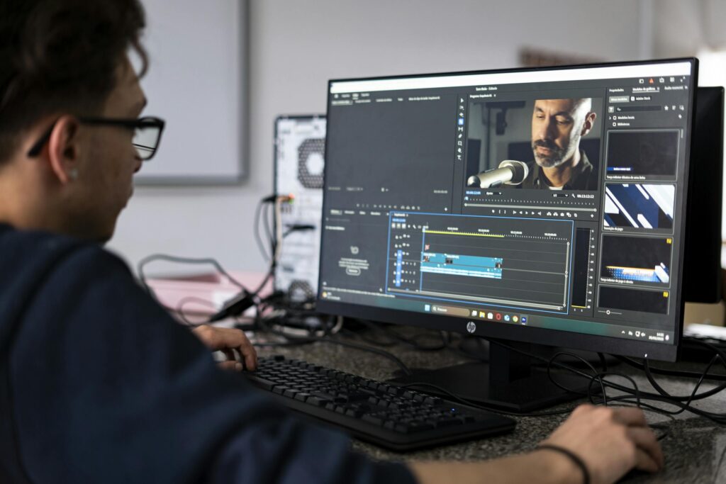 A video editor working on a project using a desktop computer in a modern office setting.