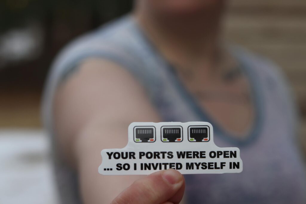 Person holding a funny internet security sticker about open ports.